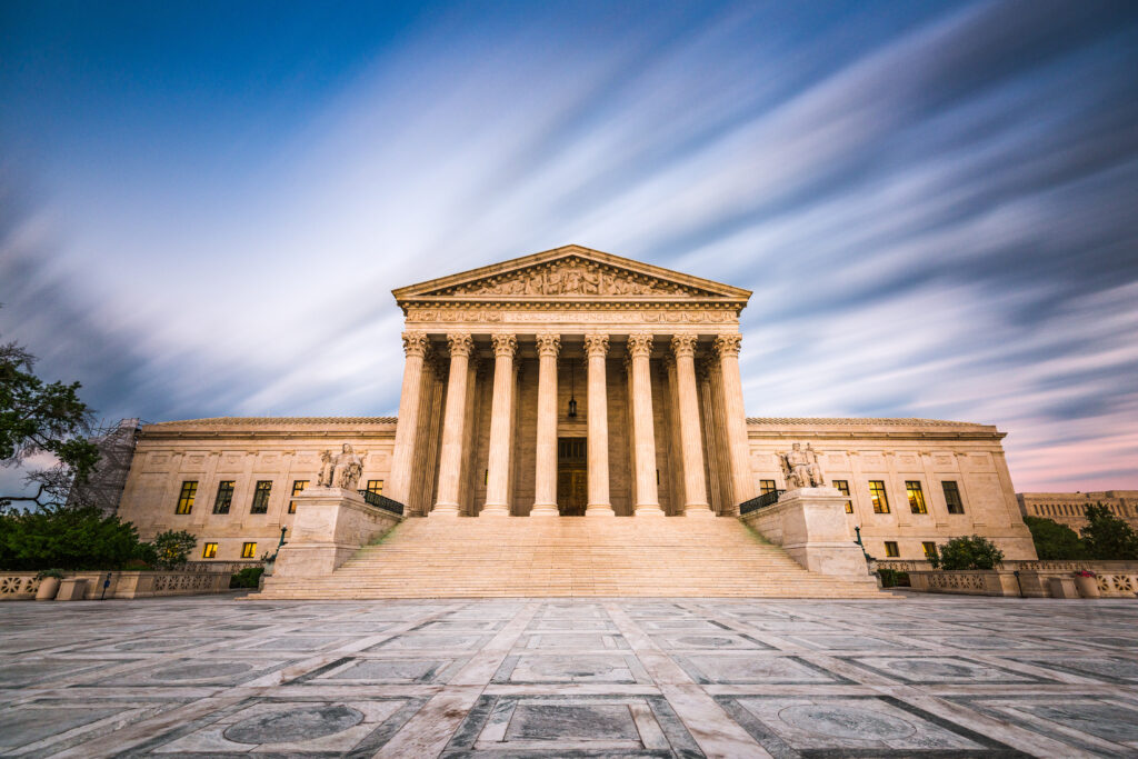 Majestic view of the U.S. Supreme Court building at dusk, with grand columns and a marble facade. A dramatic sky creates a serene and authoritative tone.